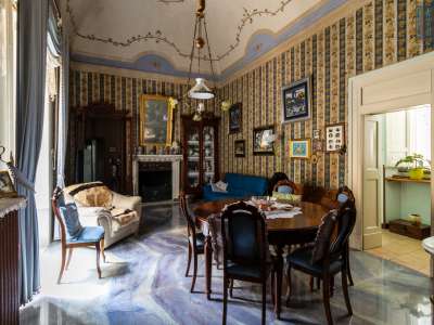 Il vano � arredato con un tavolo in legno, specchi, orologi d�epoca e cristalliere colme di porcellane